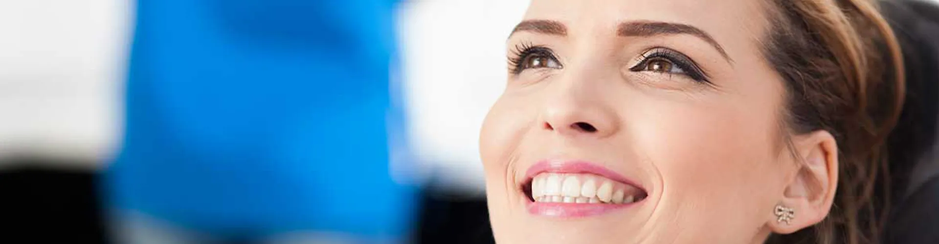 Woman smiling while sitting in dentist’s chair.