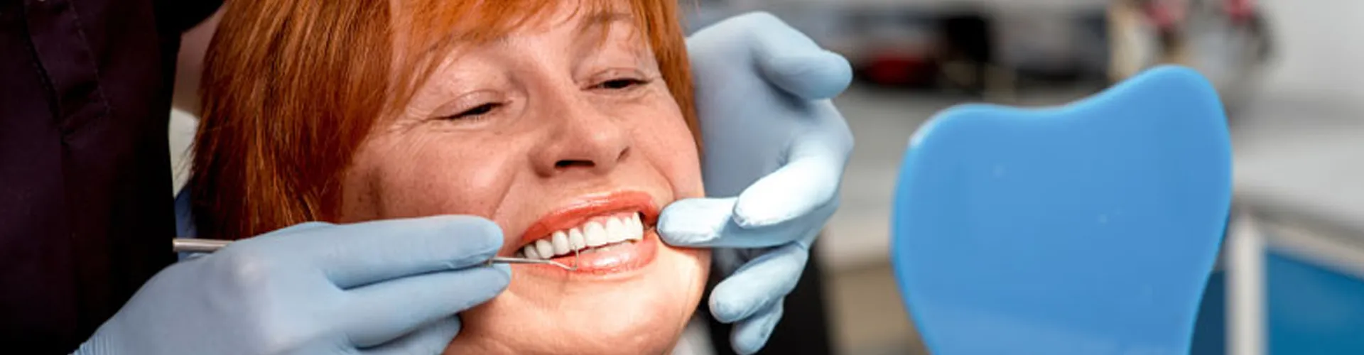 A woman smiling while getting a dental check-up.